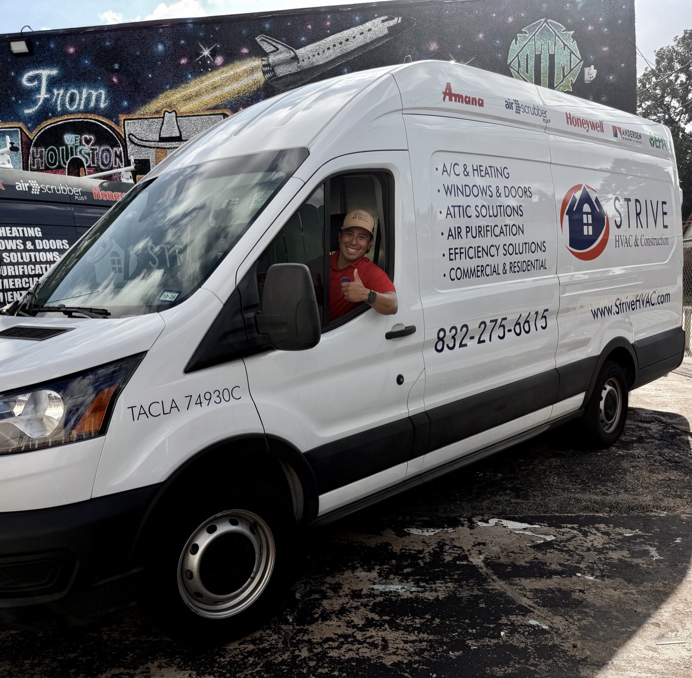 A Strive technician gives a thumbs up from one of our vans